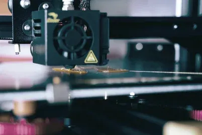 A closeup of a 3D printer in the process of printing a prototype design