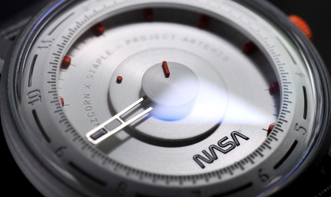 A closeup of a white timepiece with a NASA laser engraved logo on it
