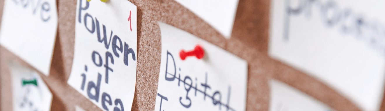 A close-up of two memo with the word “Power of idea” and “Digital” on the corkboard
