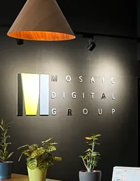The “Mosaic Digital Group” brand logo embed on a black wall as a decoration
