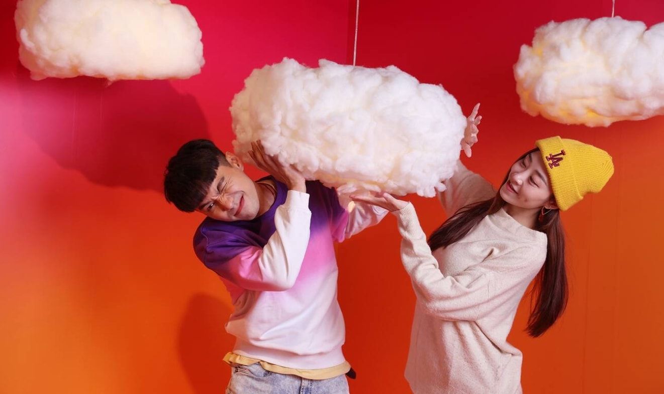 A couple plays with a cloud decorate in the colourful studio