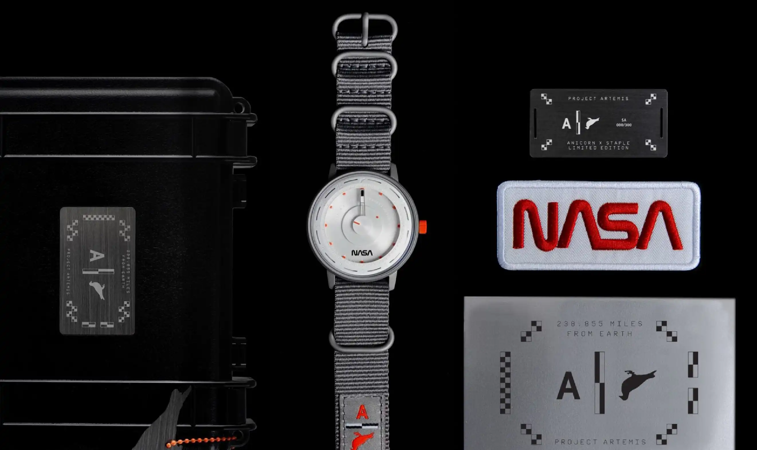 A black suitcase with a white NASA timepiece with a grey textile strap
